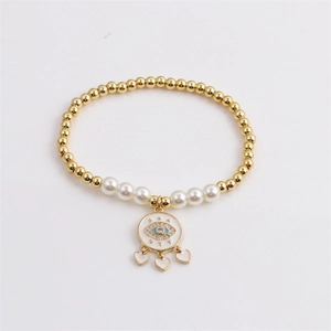 Elegant gold evil eye beaded bracelet with white pearls and small heart charms