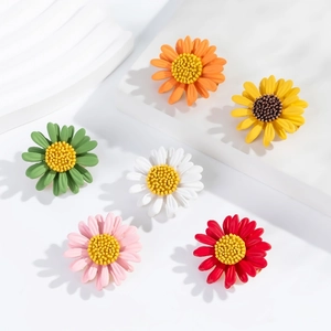 Detail shot of colorful daisy brooches in six colors on white geometric stands