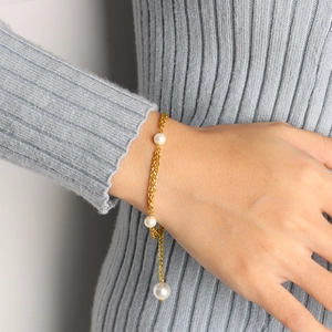 Elegant 18K gold plated chain bracelet with three white pearls on a model wrist
