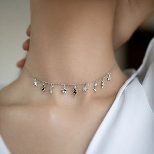 Detail view of S925 sterling silver necklace featuring star, moon, and lightning charms