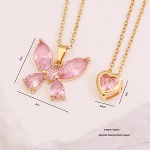 Détail de pendentifs papillon et cœur en zircon rose sur chaînes en acier doré