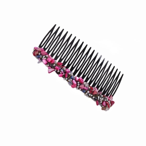 Detail view of black hair comb with pink irregular stones, white pearls and gold beads
