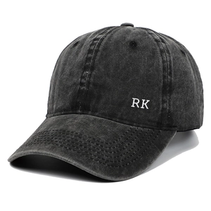 Close-up of RK letter embroidery on washed dark grey cotton baseball cap fabric