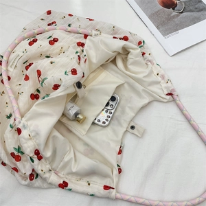 Détail du tote bag en toile cerise montrant le grand intérieur et la poche interne