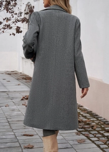 Rear view of long grey wool coat with lapel collar on model in autumn setting