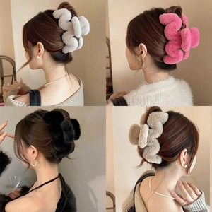 Rear view of model wearing plush wavy claw clips in white, pink, black, and beige