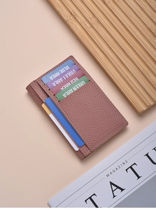 Detailed macro view of litchi texture on pink leather card holder with multiple slots