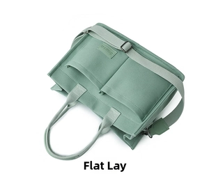 Detailed macro view of green canvas tote bag with front pockets and brand label