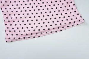 Close-up of pink mesh top hem with black polka dot pattern and detailed stitching