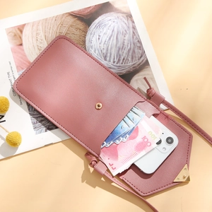 Pink crossbody phone wallet with heart buckle and multi-card slots shown with accessories