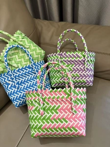 Detail of four colorful checkered woven basket bags on a leather sofa for gifts