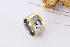 Detail of two-tone wide ring with heart-shaped blue gemstone and white zircon accents