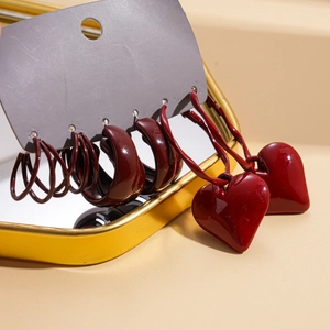 Detail of a six-piece red enamel geometric heart hoop earring set on grey card