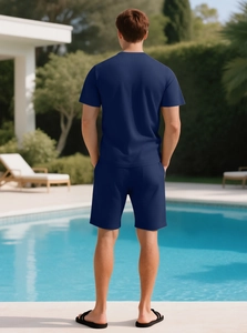 Rear view of a navy blue waffle knit short set on a model by an outdoor pool