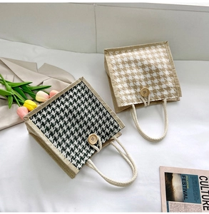 Detail of woven houndstooth handbag with thick cotton rope handle and wooden button