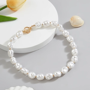 Detail of baroque pearl necklace with golden OT clasp and decorative seashell and flower