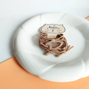 Close-up of five durable brown elastic hair ties on a cute cat-shaped card holder
