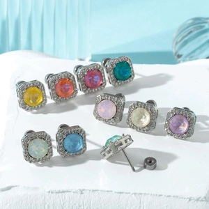 Colorful sugar-cube square stud earrings with screw backs on a textured white surface