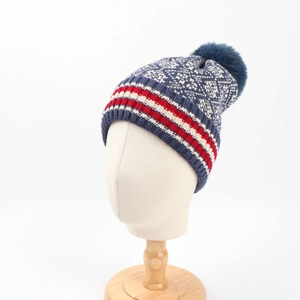 Navy winter knit beanie with Fair Isle snowflake pattern and a faux fur pom pom