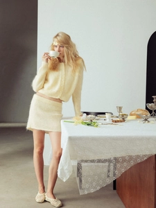 Elegant cream knit cardigan and mini skirt set with pearl buttons on female model