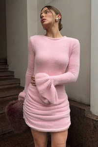 Détail de la robe en maille rose avec manches cloches et texture en tissu pelucheux