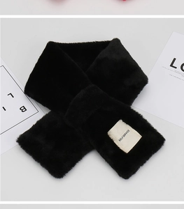 Detail of soft black faux rabbit fur scarf with woven label and plush texture