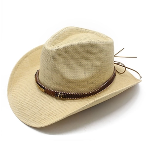 Detail of woven beige cowboy hat with brown band, metal leaf charm and dark beads