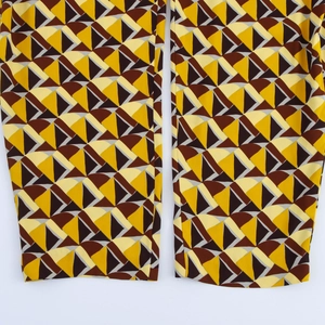 Dettaglio della trama del tessuto del set camicia con motivi geometrici giallo e marrone