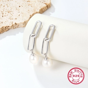 Macro detail of long 925 sterling silver chain earrings with natural white pearls