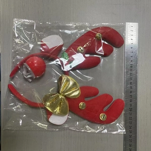Close-up of red reindeer antler headband set with gold bells in transparent packaging