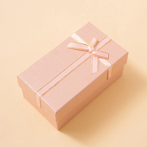 Elegant rectangular pink jewelry gift box with a textured finish and golden stitched ribbon
