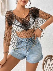 Détail du cache-maillot au crochet noir avec glands de perles dorées et motif résille