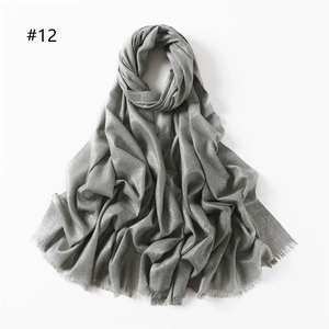 Close-up of silver-gray scarf with metallic shimmer threads and frayed fringe edges