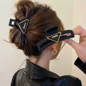 Matte black acrylic triangle hair claw clip with golden POWER letter design for women