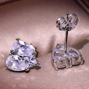 Macro shot of silver heart earrings featuring two pear-cut cubic zirconia and butterfly back