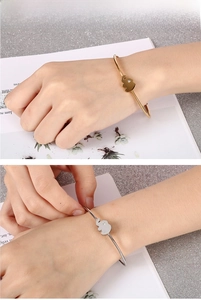 Detail of minimalist elephant open bangle in gold and silver finish with diamond accent