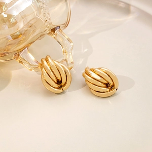 Boucles d'oreilles croissant dorées avec texture métallique nervurée et poli brillant
