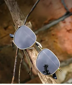 Detail view of gold metal sunglasses frame resting on natural wood background