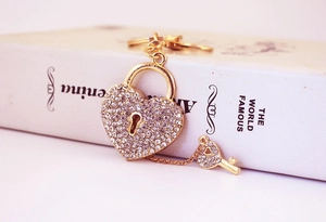 Close-up of golden heart lock and key keychain set with sparkling crystal rhinestones