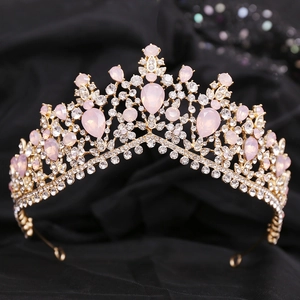 Detailed close-up of golden baroque tiara with pink pear-cut rhinestones on black silk