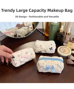 Quilted floral cotton makeup pouches with decorative bows and zip closure on wood table