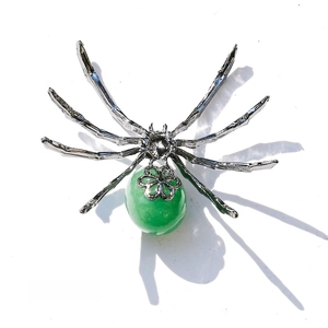 Detailed back view of a spider figurine featuring green crystal and silver metal frame