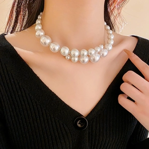 Close-up of double-layered faux pearl choker necklace with silver bead accents on a model