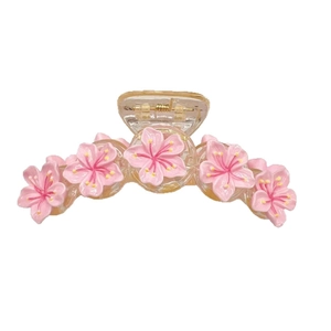 Pink cherry blossom hair claw clip with five resin flowers on a transparent amber base