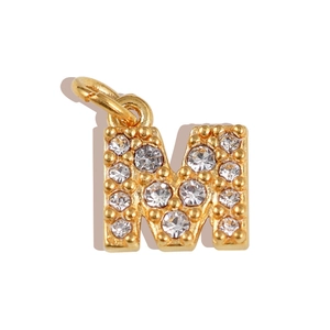 Macro view of a gold-plated letter M pendant featuring sparkling inlaid rhinestones