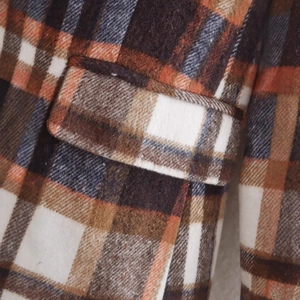 Close-up of brown plaid wool blazer featuring detailed pocket flap and brushed texture