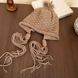 Handmade knit beanie with warm earflaps and long braided tassels in cozy camel color