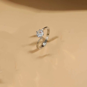 Detailed close-up of a silver six-prong solitaire ring with open design on finger