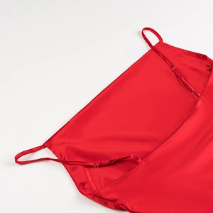 Dettaglio dell'abito in raso rosso con spalline sottili regolabili e texture seta