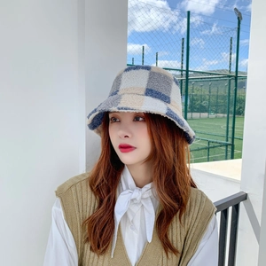 Close-up of fluffy checkerboard bucket hat in blue and white plush material on model